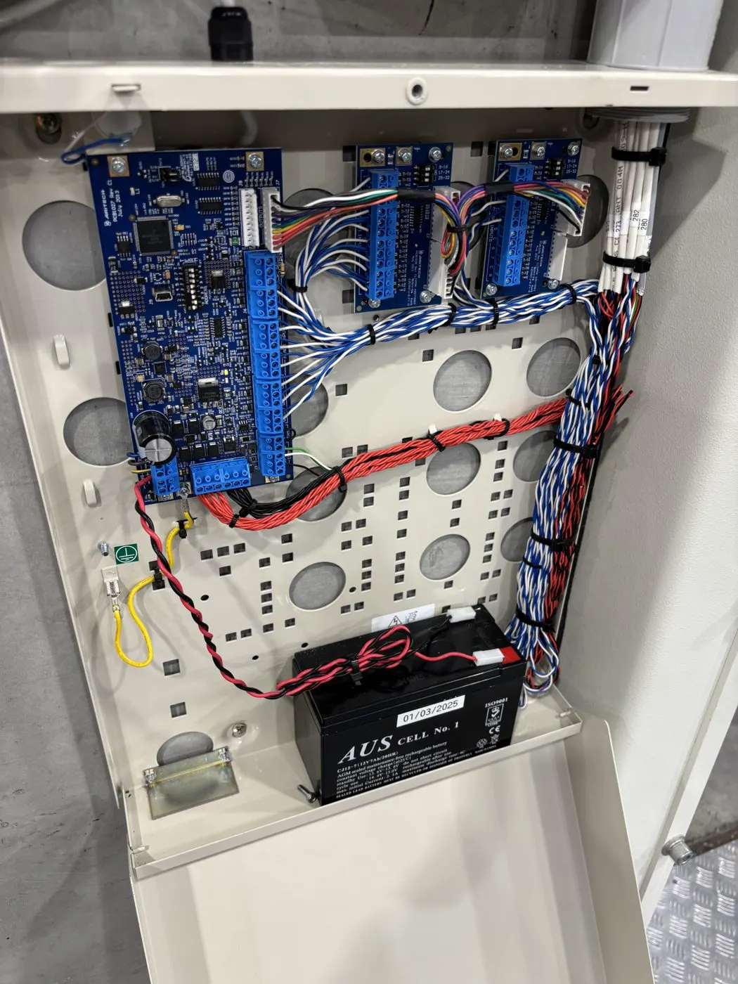 Intrusion alarm panel with backup battery, neatly wired into a steel enclosure