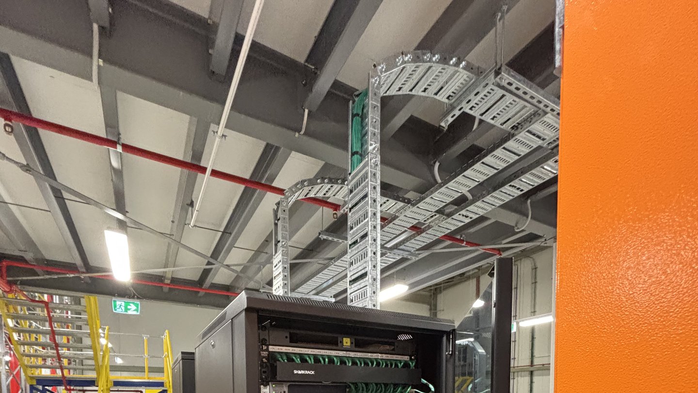 Comms cabinet under overhead cable tray inside the pharmaceutical distribution centre
