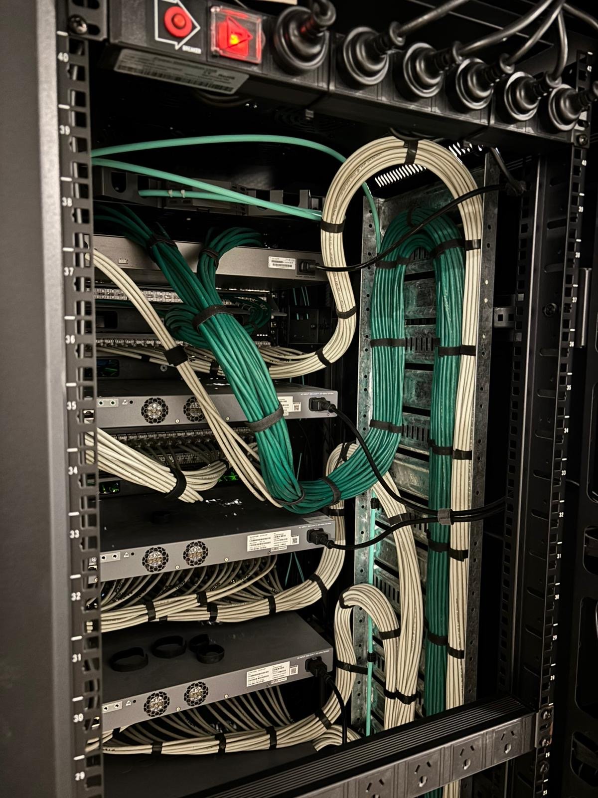 Cable management on a data centre comms cabinet, neat green and white patch leads