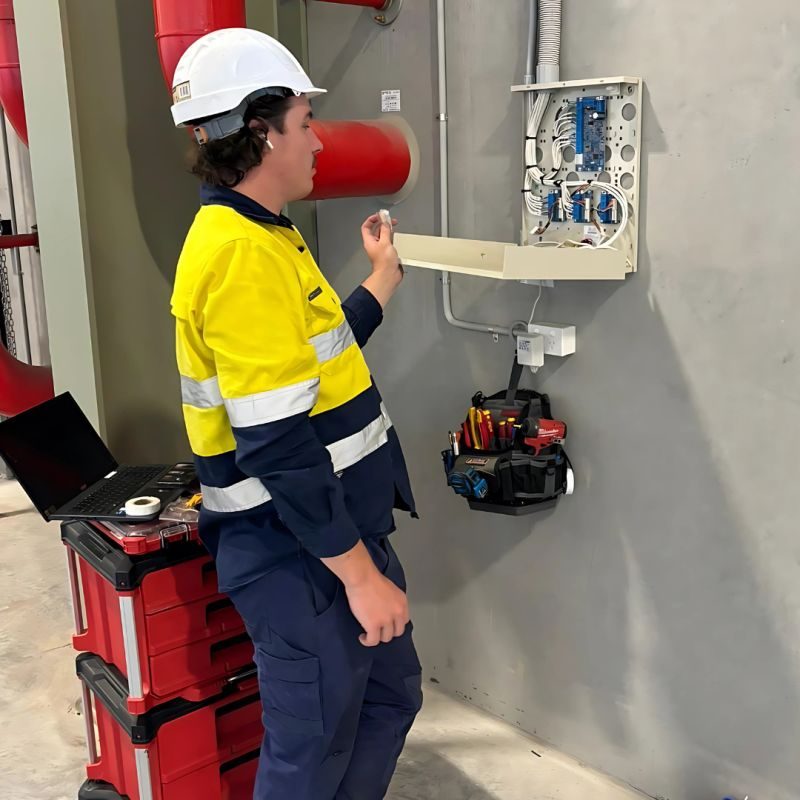 Ktronics technician commissioning a wall-mounted intercom and access control panel at a Sydney commercial site