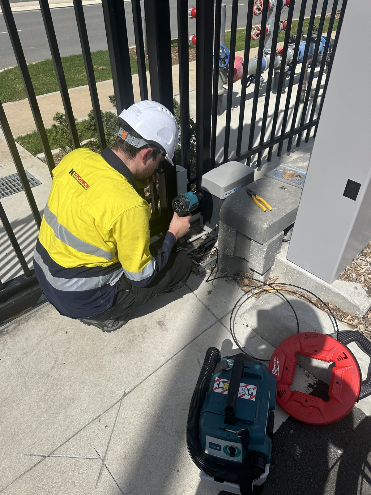 Ktronics technician on-site servicing security hardware at a Sydney commercial property